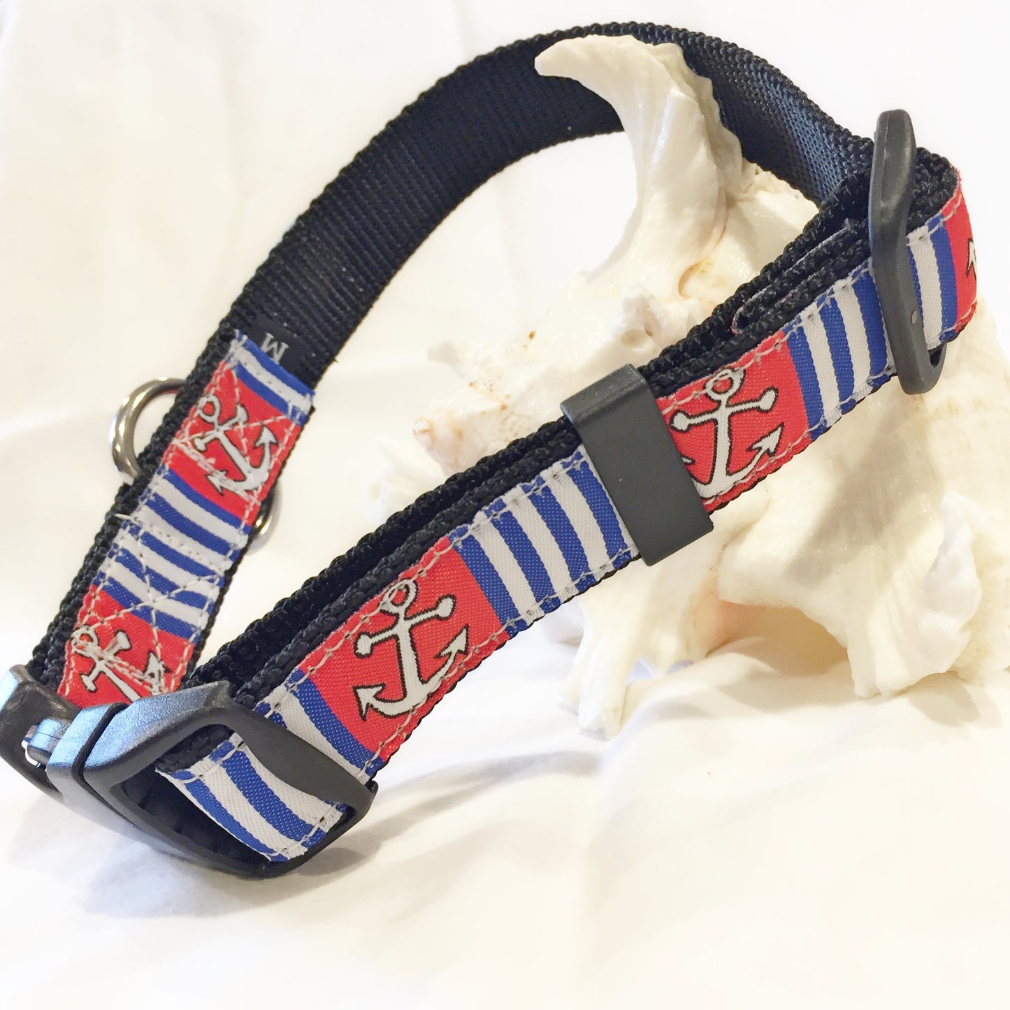 Nautical-themed dog collar with anchors and stripes on a white background for saltwater use